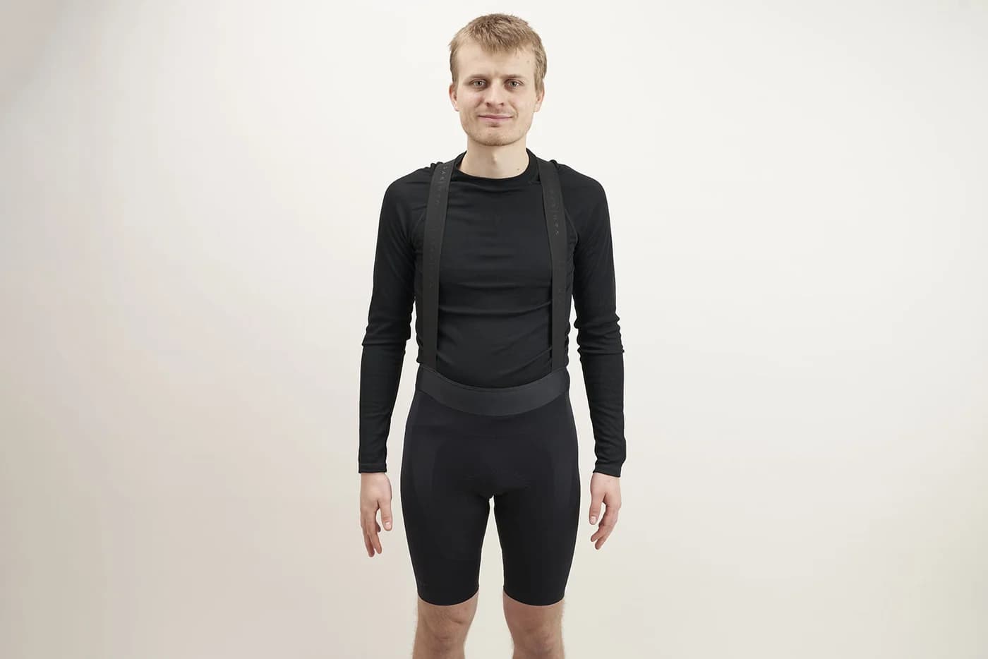 Cyclist wearing Van Rysel Racer 2 black bib shorts with branded shoulder straps